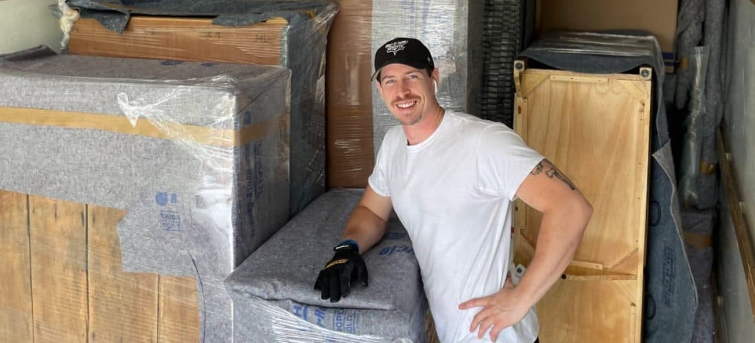 Asheville Moving Pros staff member smiles with hand on his hip in the back of a moving truck